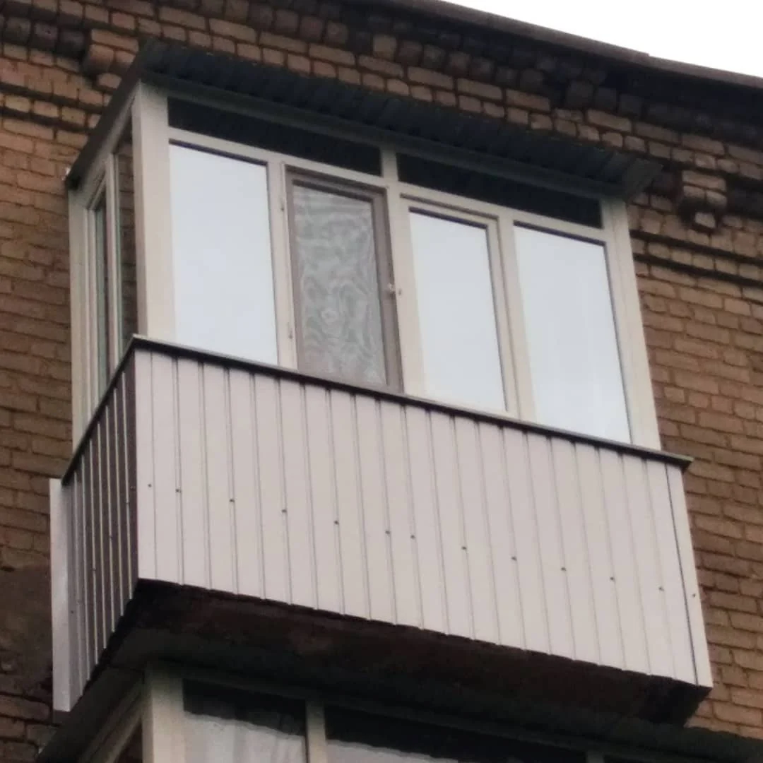 Балкон із білими рамами та світлою вертикальною обшивкою