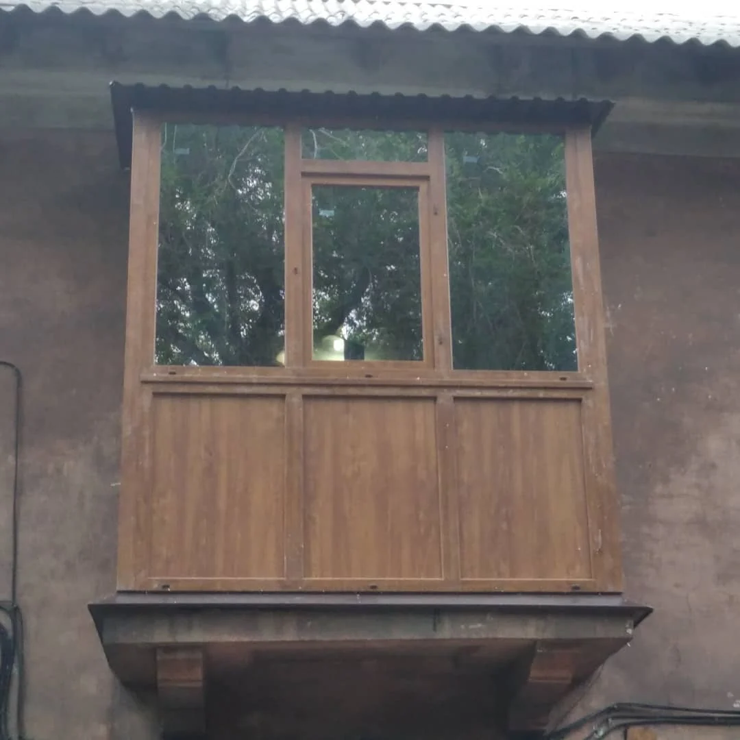 Балкон із рамами й обшивкою в коричневих тонах