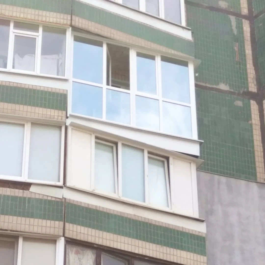 Світле балконне скління на фасаді багатоповерхового будинку