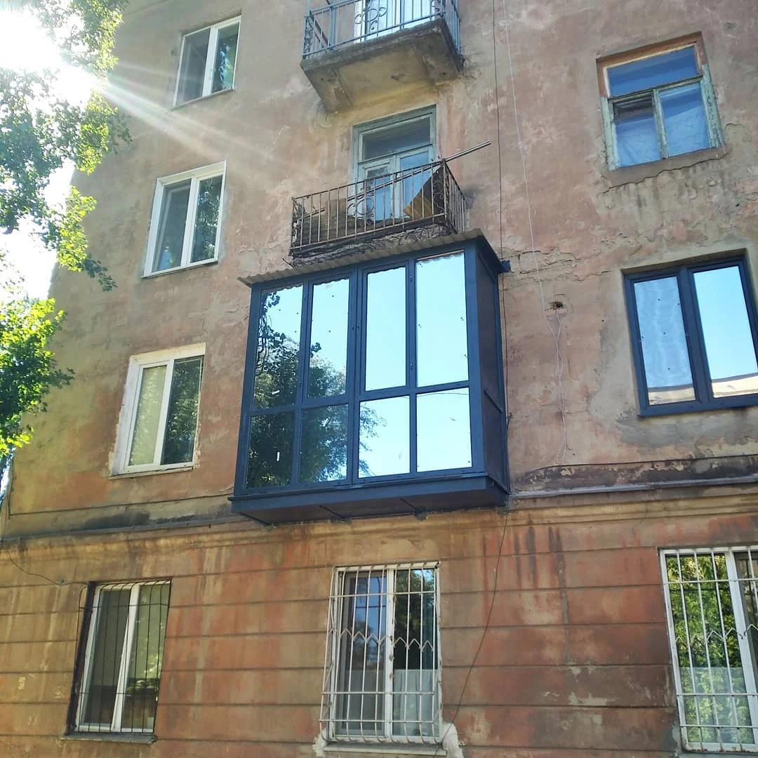 Компактний балкон із темною рамою на жовтому фасаді
