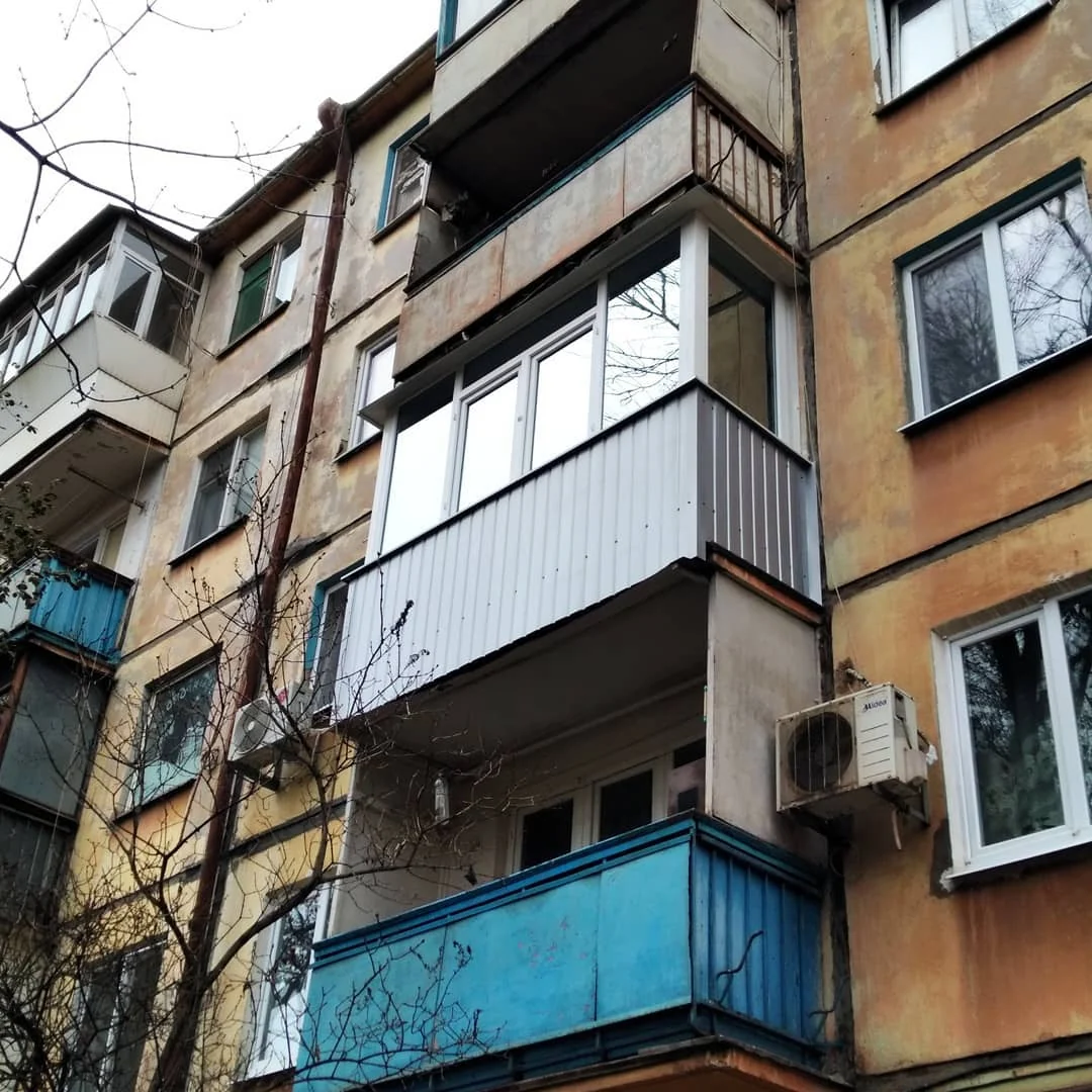 Кутовий ракурс балкона з білими рамами