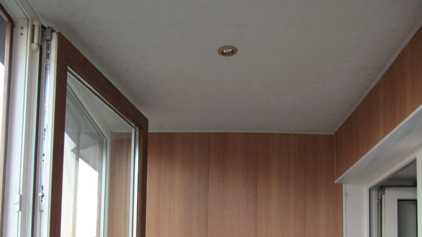 Біла стеля з точковими світильниками над обшивкою