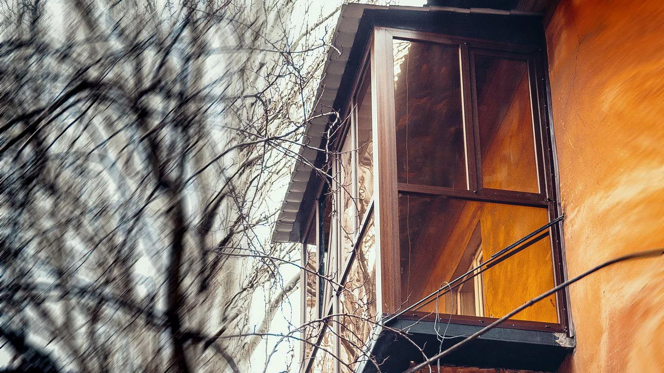 Висока балконна конструкція в коричневих тонах: бічний ракурс