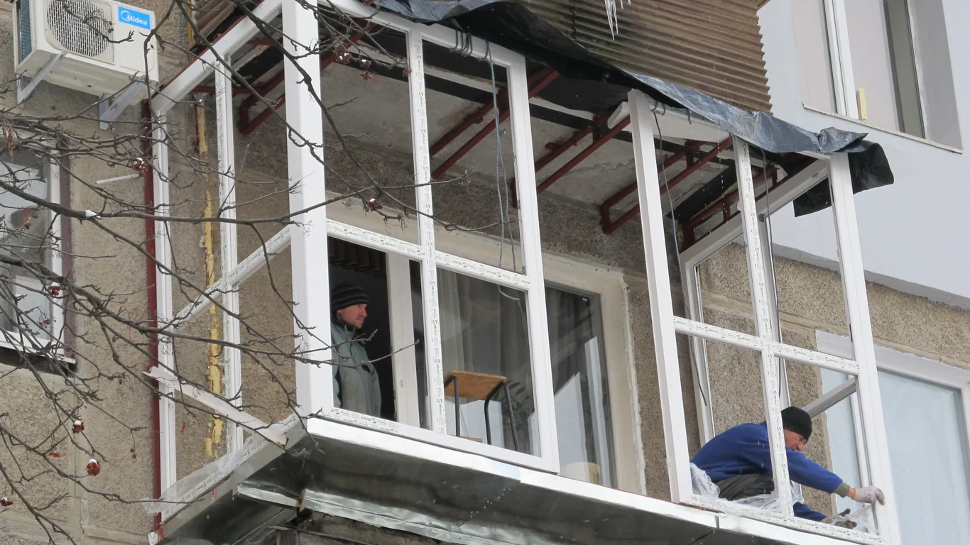 Монтаж білих високих рам на балконі