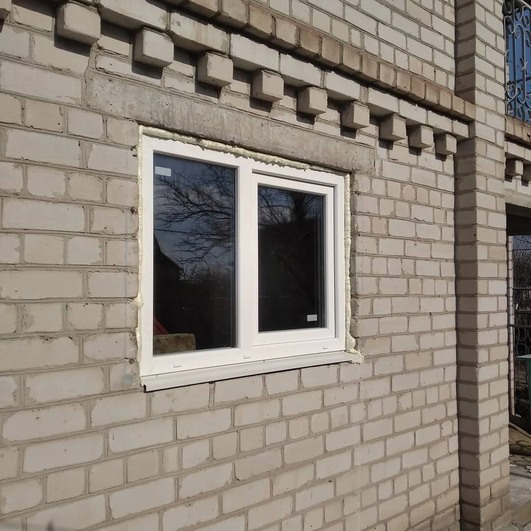 Біле вікно з оформленими зовнішніми укосами