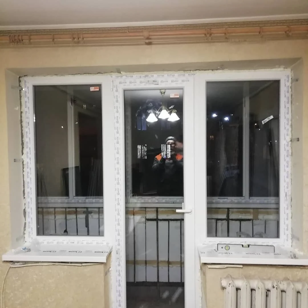 Балконний блок із білими рамами та зачиненими дверима