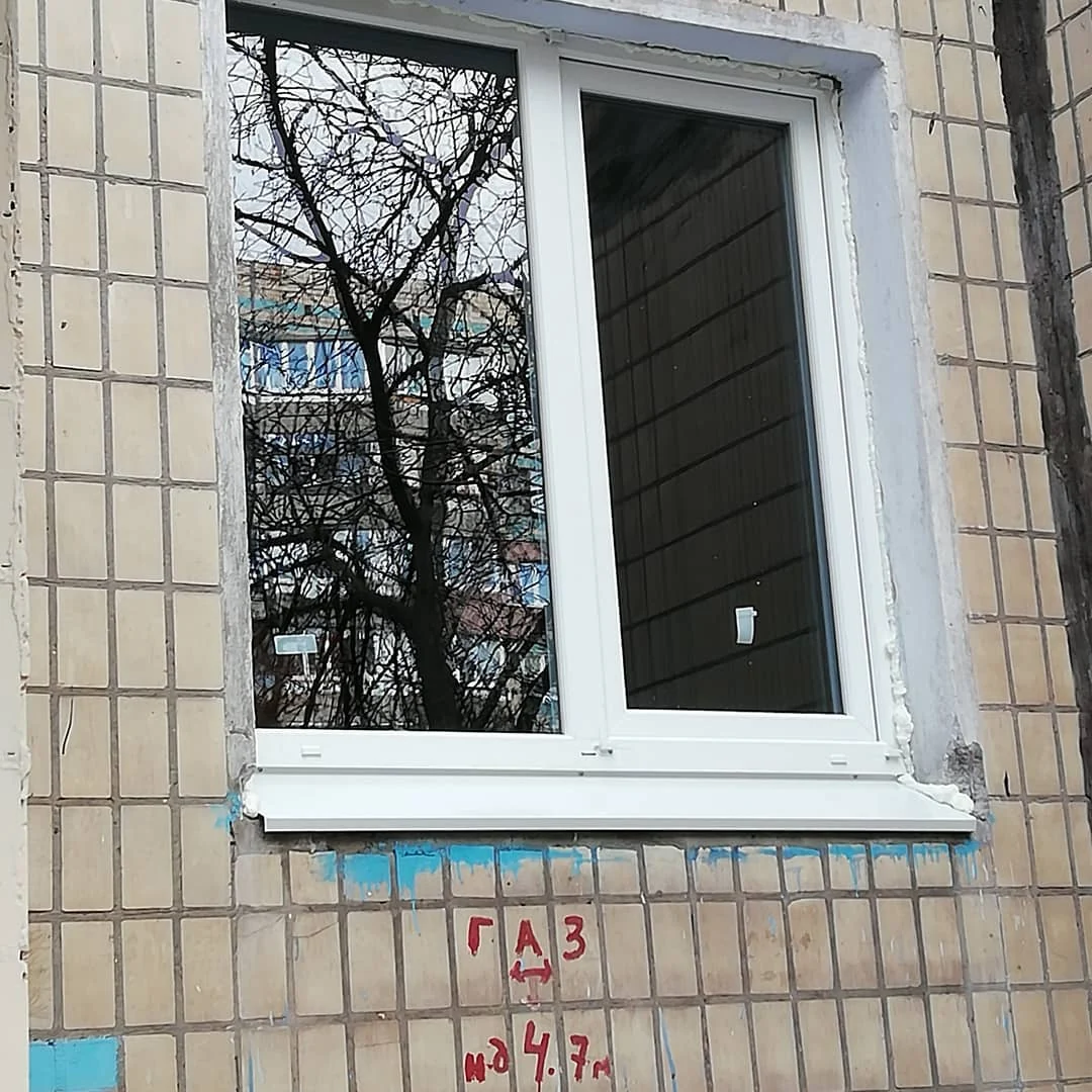 Біле вікно на облицьованому фасаді: зовнішній ракурс і підвіконня