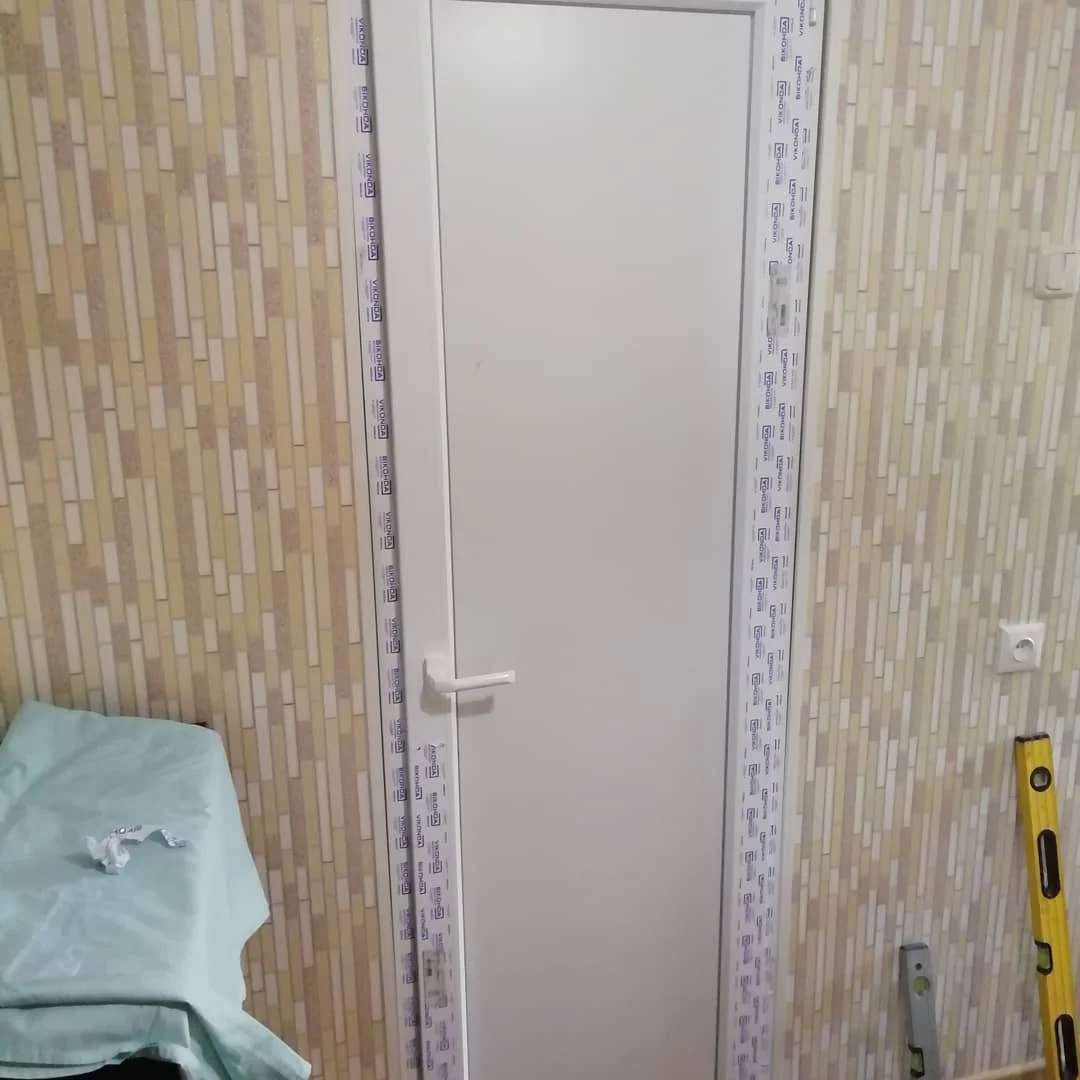 Білі двері із суцільною вставкою під час монтажу