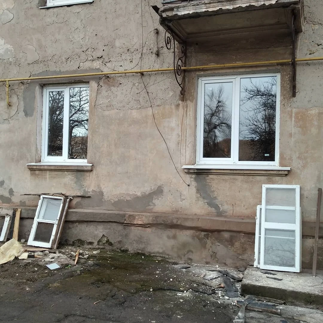 Два білі вікна на фасаді під час робіт: загальний план